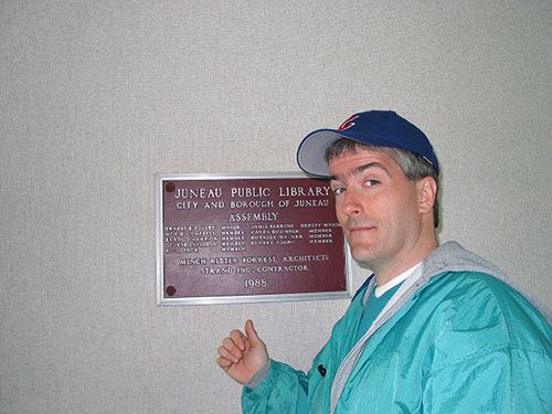 Pat in front of sign for the library