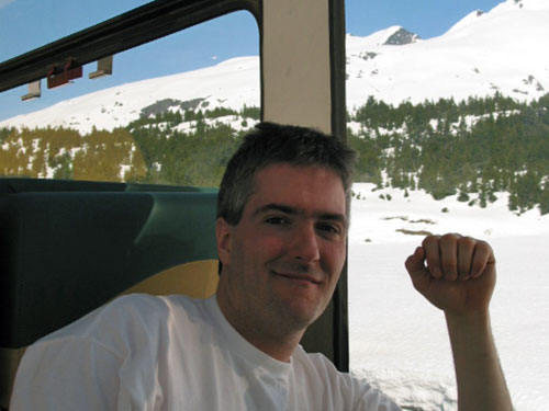 Pat in front of window of mountains covered with snow