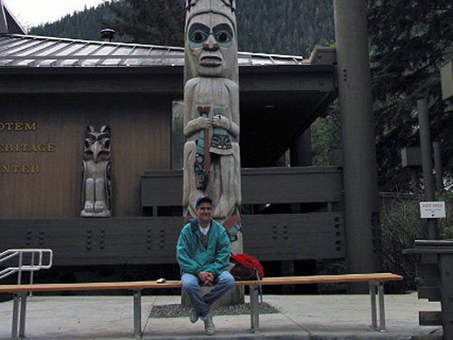 Pat sits at base of a totem pole