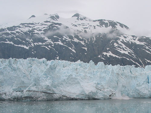 Glacier calving with mountain in the background