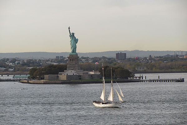Sailboat passes in front of Statue of Liberty