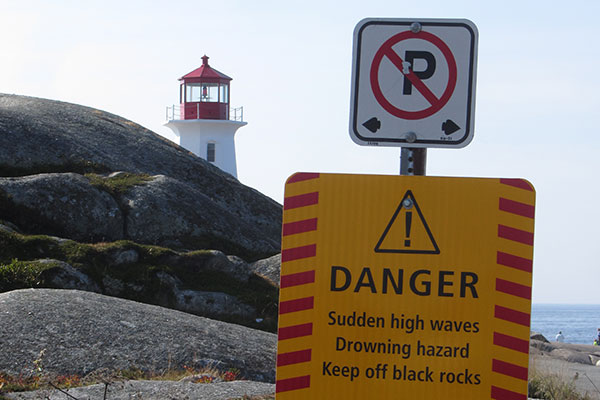 Lighthouse beyond danger sign
