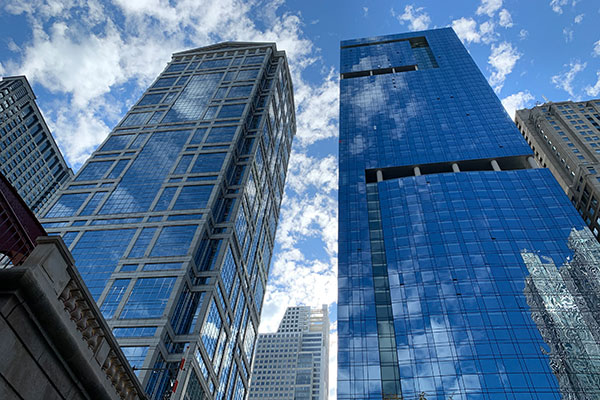Buildings with clouds reflecting off glass