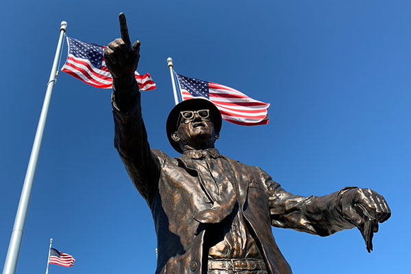 George Hala statue with flags in the background