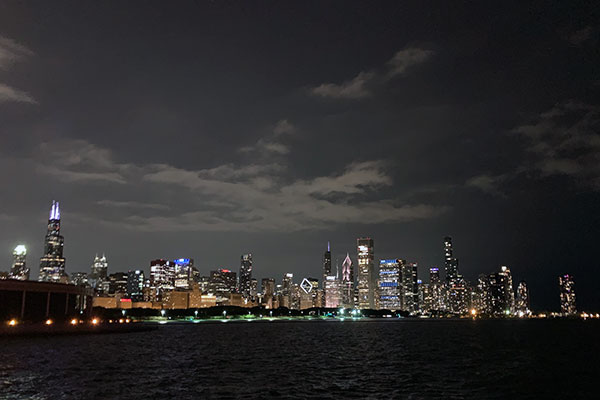 Chicago skyline behind Lake Michigan at night
