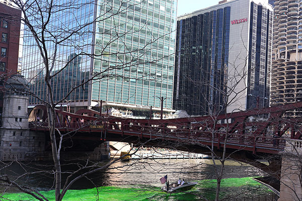 Boat dyeing the Chicago River green goes under bridge