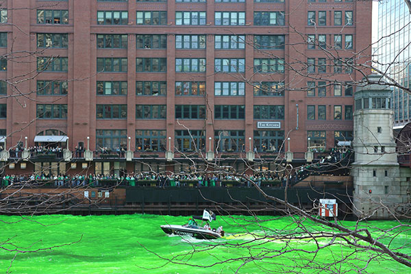 Boat with flag as they celebrate dyeing the Chicago River green