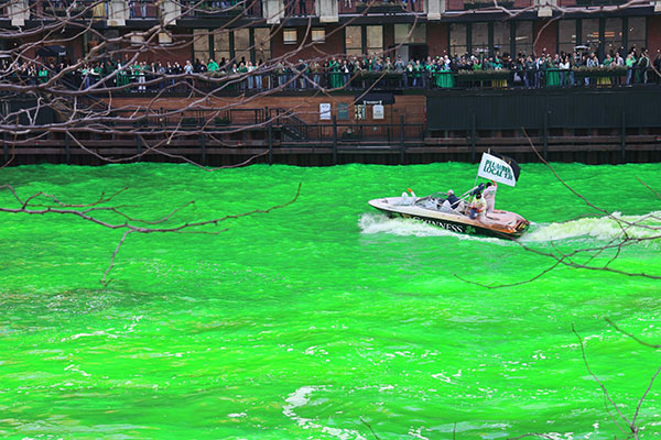 Flag on back of boat as they dye the Chicago River green