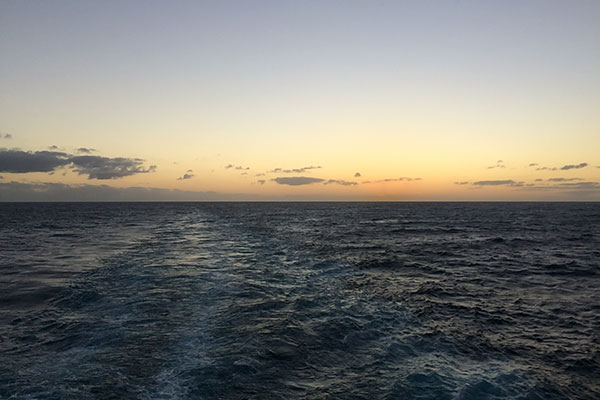 Sun sets behind boat