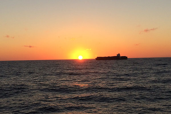 Ship passes by as sun sets