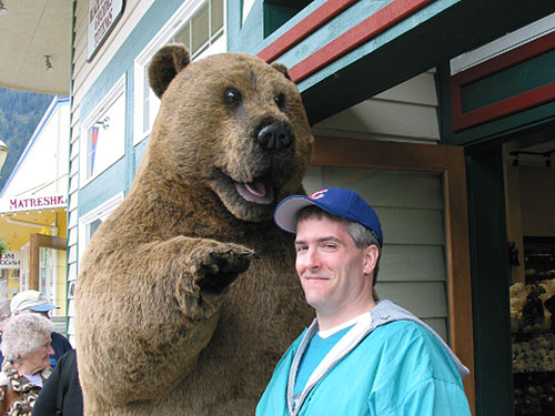 Pat with stuffed bear towering over him