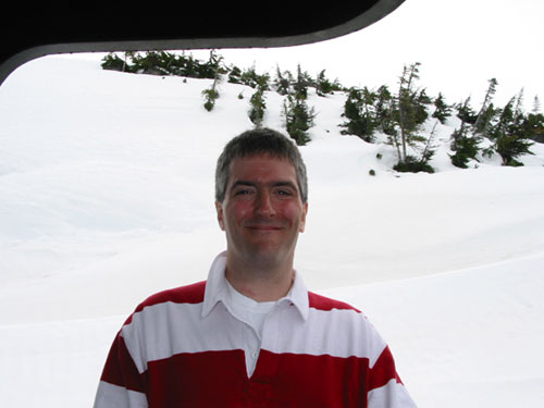 Pat standing on train with snow behind him