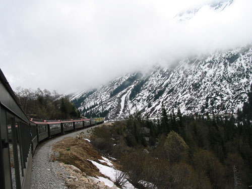 Train passes through fog and snow covered mountains