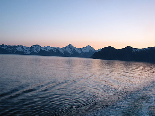 Mountain beyond water at sunset