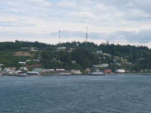 Buildings on shore with hills in the background