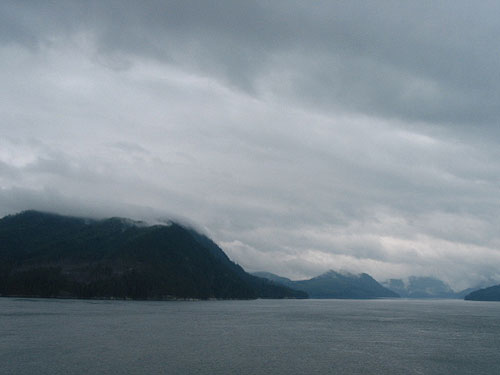 Low hanging clouds on the mountains beyond the water