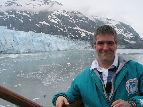 Pat leaning against the stairwell in front of glacier