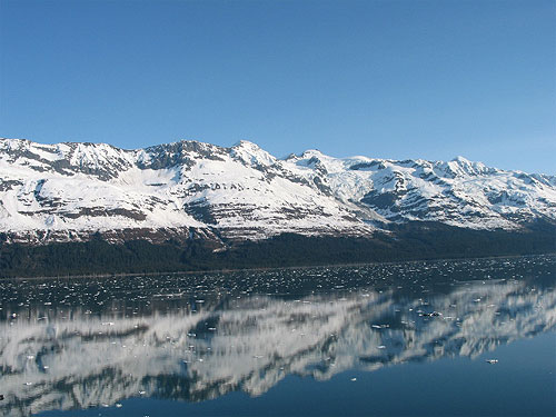 Snow filled mountain with water in foreground