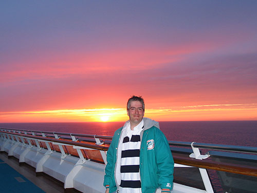 Pat smiling with sunset in background