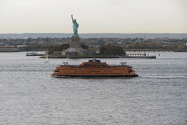 Ferry passes in front of Statue of Liberty