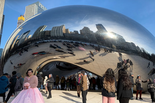 Girl holding flowers in front of Cloud Gate in Millennium Park