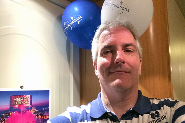 Pat in front of door with balloons