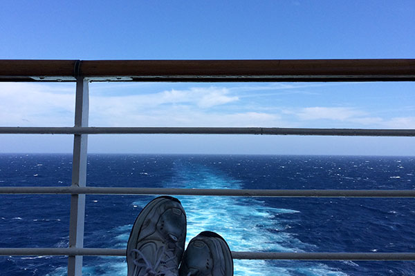 Feet up on chair with water behind rail