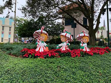 Statue display of three girls with umbrellas