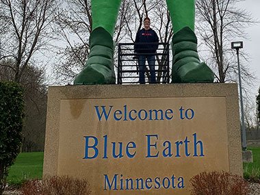 Pat standing under Jolly Green Giant Statue