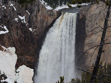 Yellowstone National Park waterfall with snow next to it