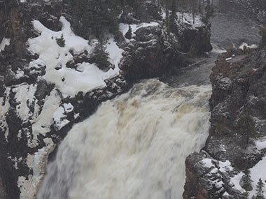 Snow falls over waterfall