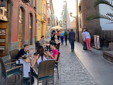 People at tables next to street