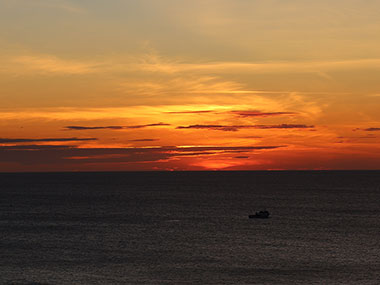 Boast passes in front of setting sun