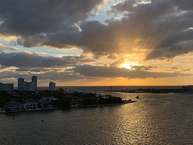 Buildings and boats in distance in front of sunrise