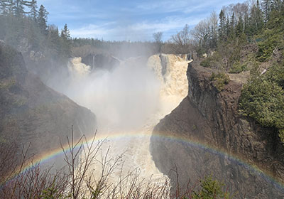 Rainbow in front of waterfall with mist