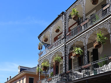 Ferns hang in baskets from balcony
