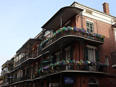 Flowers adorn balcony of red building