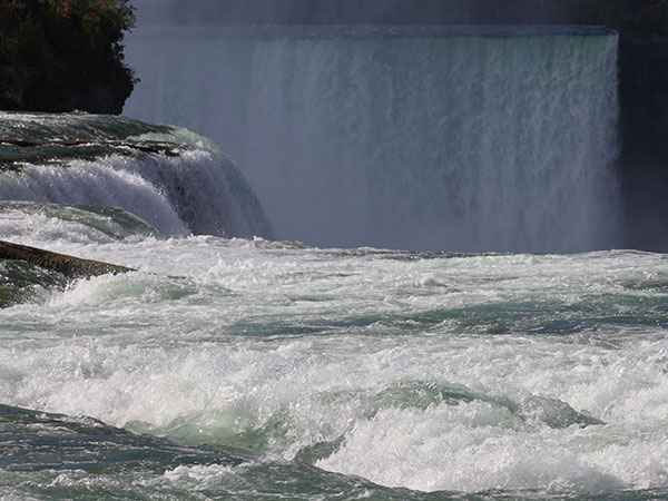 Closeup of Niagara Falls from behind it on the American side