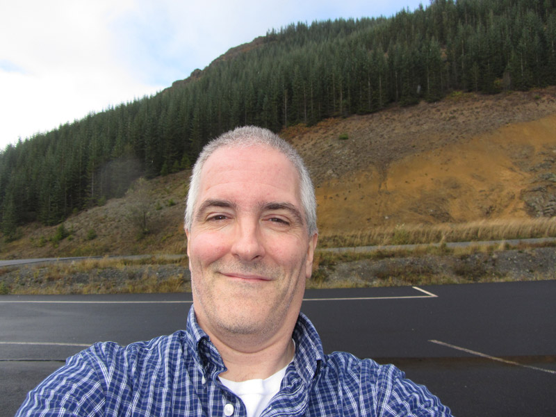 Pat with road and hills on way to Mount St. Helens