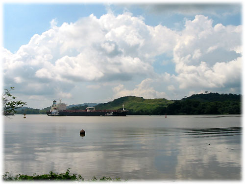 Cargo ship passes by train on the canal