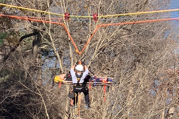 Rescue worker trains ibn the air over a canyon