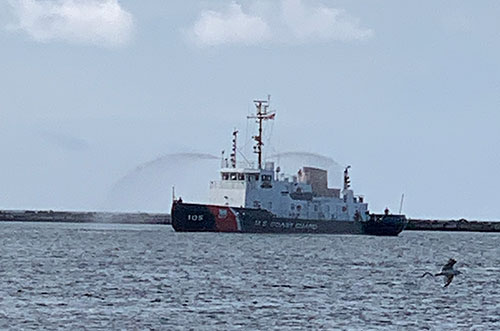 Tugboat spraying water canons